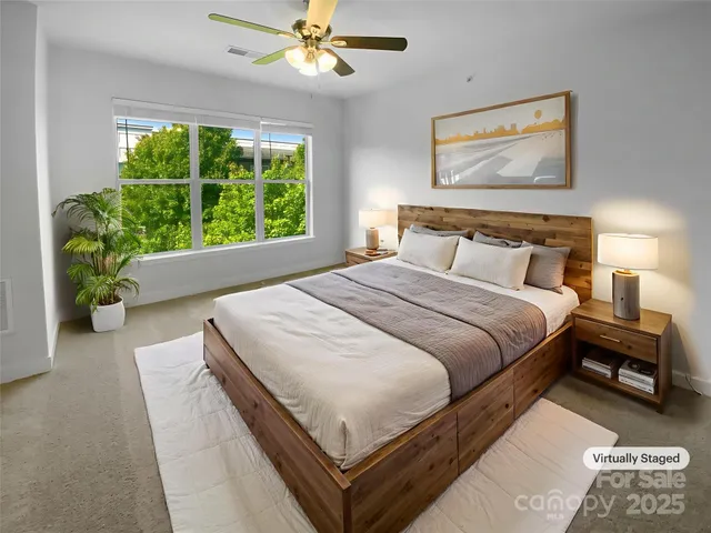 a bedroom with a bed and a large window