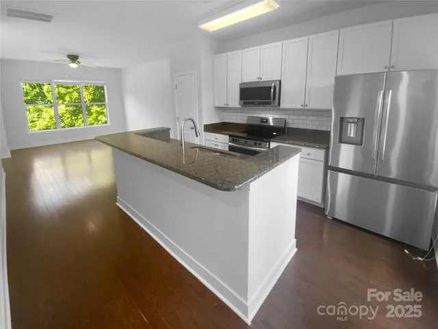 a kitchen with a refrigerator and a stove top oven