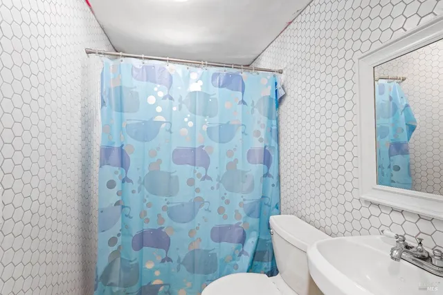 a white toilet sitting next to a bathroom sink