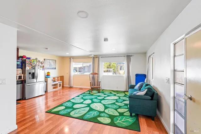 a living room with furniture floor to ceiling window and wooden floor