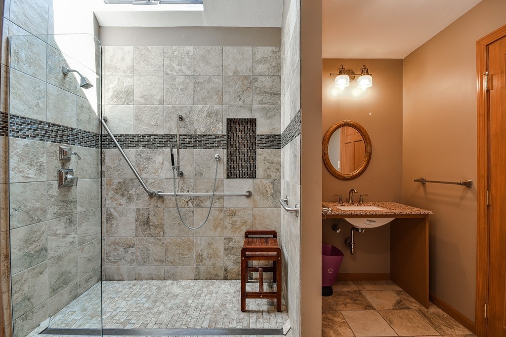 41 Garvey Road Framingham, MA 01701 - Photo 13 of 22 a bathroom with a sink a mirror and a shower