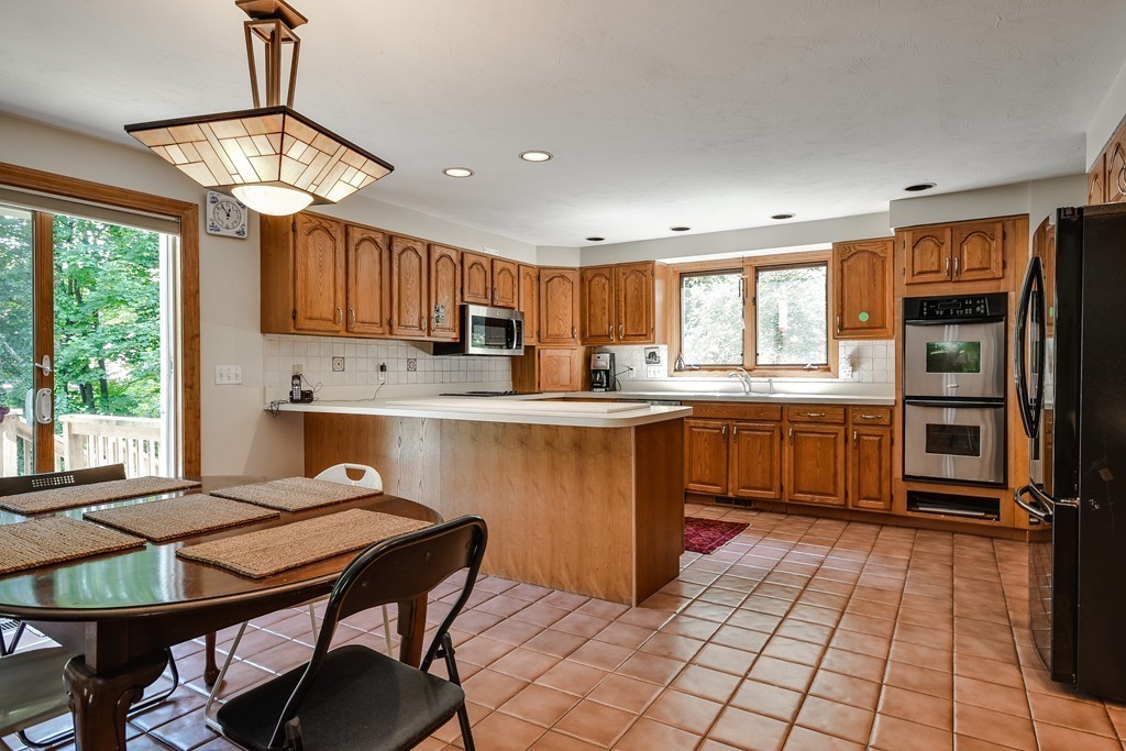 41 Garvey Road Framingham, MA 01701 - Photo 8 of 22 a kitchen with a table chairs microwave and cabinets