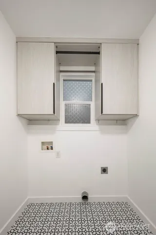 a view of a utility room with cabinet dryer and washer