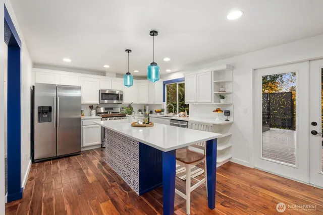 a kitchen with kitchen island a sink appliances and wooden floor