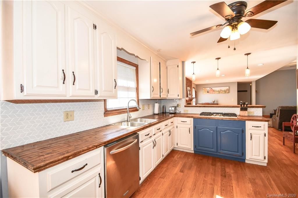 1408 Mills Harris Road Wingate, NC 28174 - Photo 12 of 23 a large kitchen with cabinets wooden floor and stainless steel appliances