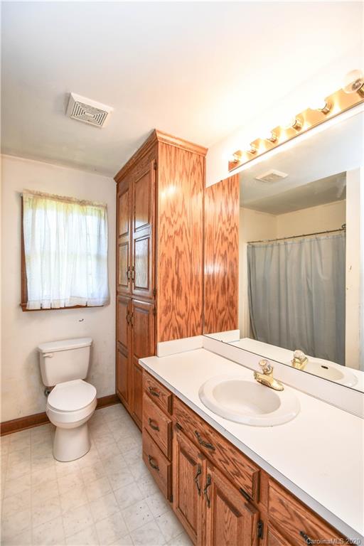 1408 Mills Harris Road Wingate, NC 28174 - Photo 17 of 23 a bathroom with a sink toilet a mirror and vanity