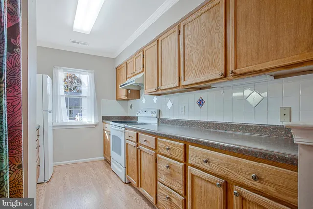 a kitchen with stainless steel appliances granite countertop a refrigerator and a stove