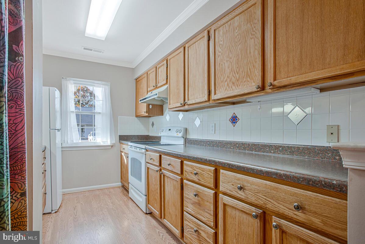 9264 Cherry Lane, Unit 47 Laurel, MD 20708 - Photo 17 of 32 a kitchen with stainless steel appliances granite countertop a sink and cabinets with wooden floor
