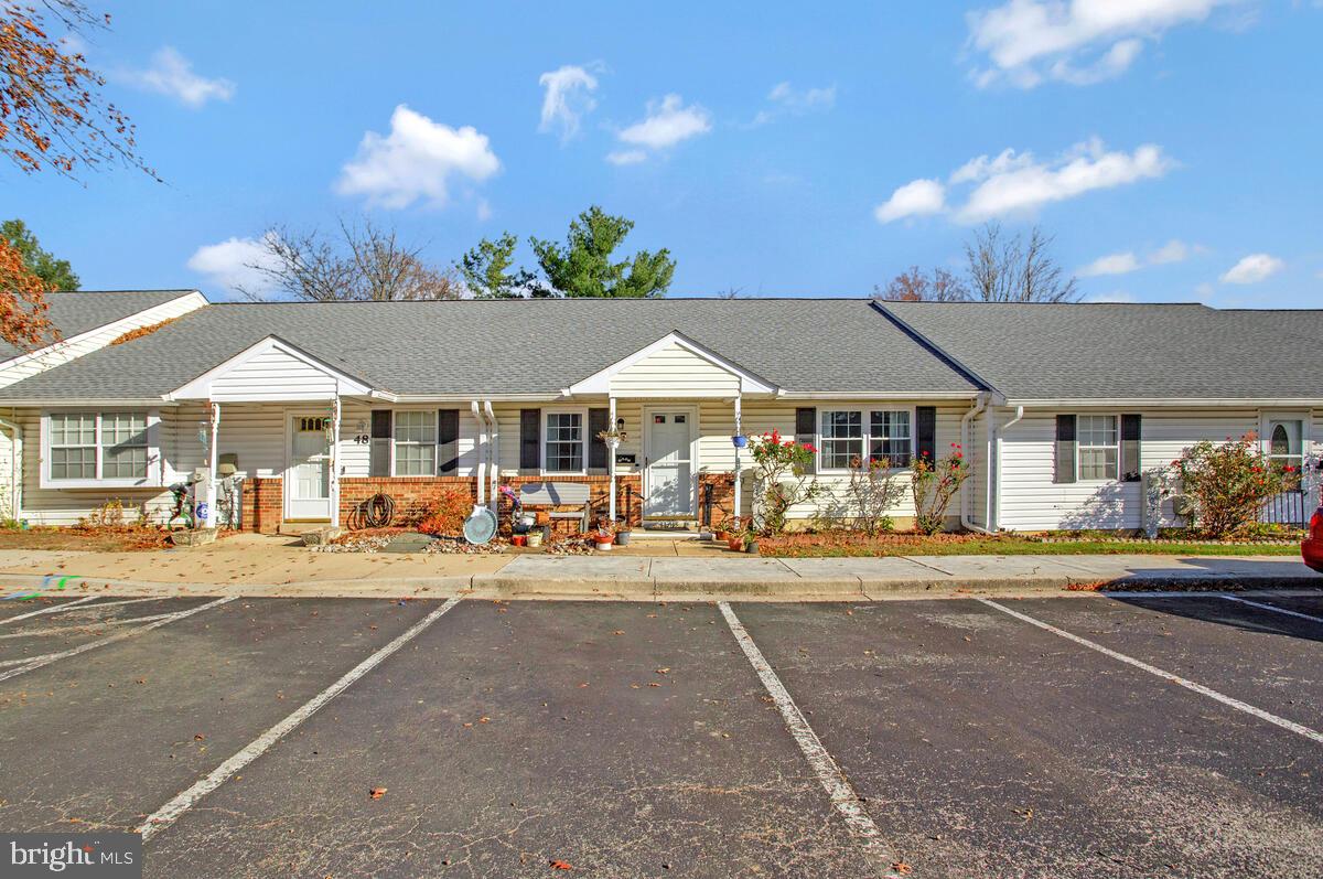 9264 Cherry Lane, Unit 47 Laurel, MD 20708 - Photo 2 of 32 a front view of a house with table and chairs under an umbrella