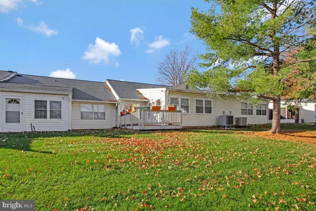 a view of a house with a yard and large tree