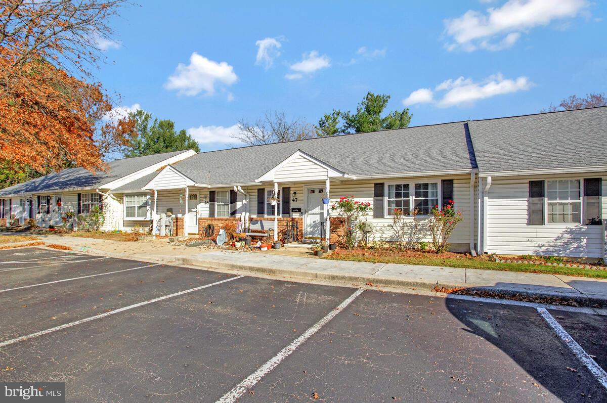 9264 Cherry Lane, Unit 47 Laurel, MD 20708 - Photo 3 of 32 a front view of a house with swimming pool and dinning table and chairs under an umbrella