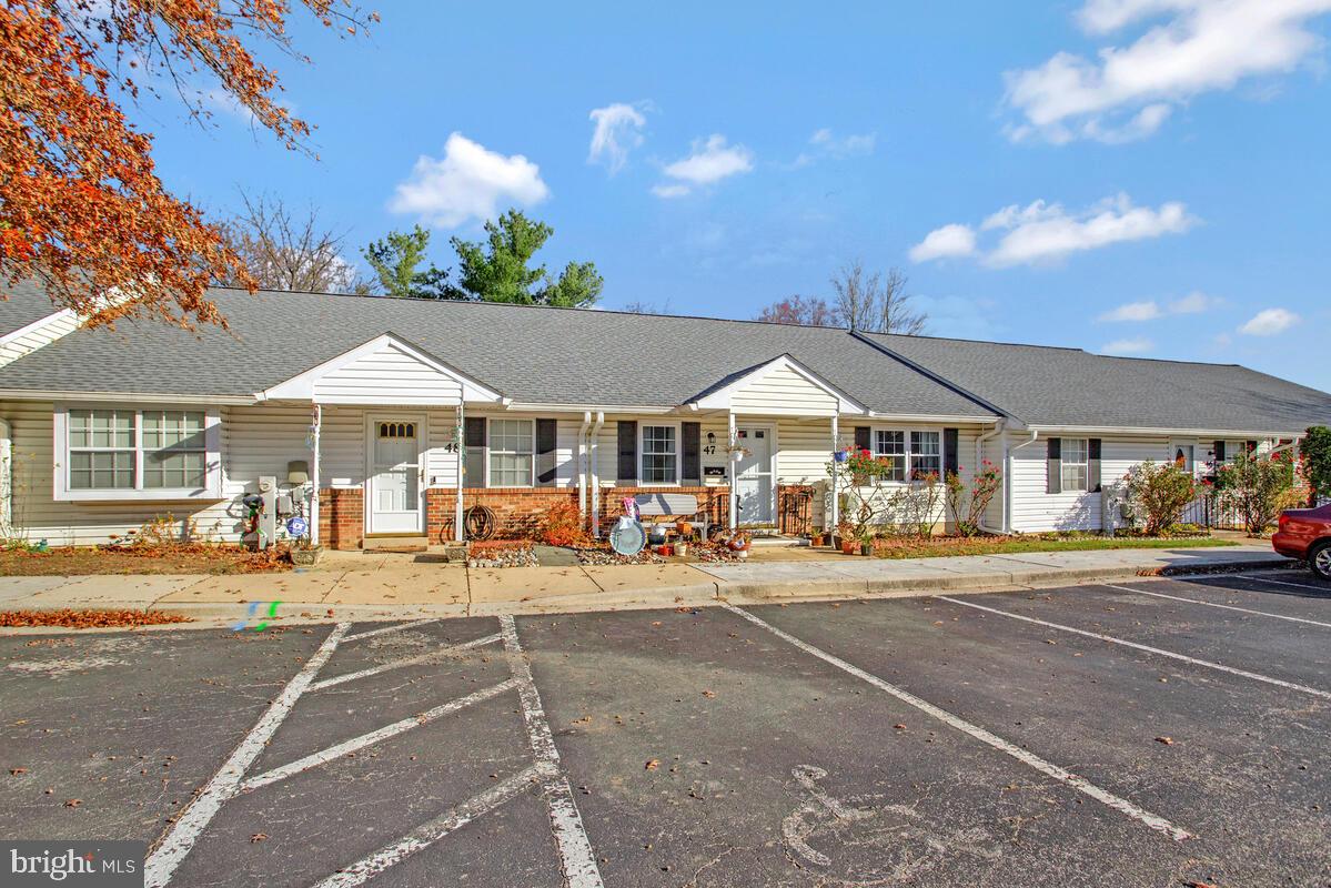 9264 Cherry Lane, Unit 47 Laurel, MD 20708 - Photo 4 of 32 a patio with a table and chairs under an umbrella