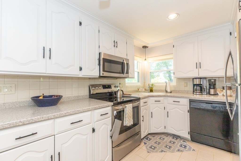 33 Keyes Road Westford, MA 01886 - Photo 17 of 42 a kitchen with stainless steel appliances granite countertop a sink a stove and cabinets