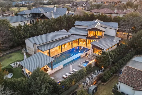 an aerial view of a house with swimming pool and outdoor seating