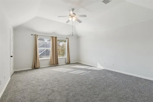 an empty room with fan and windows