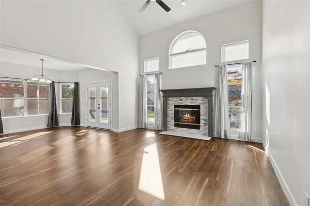a view of an empty room with wooden floor fireplace and a window