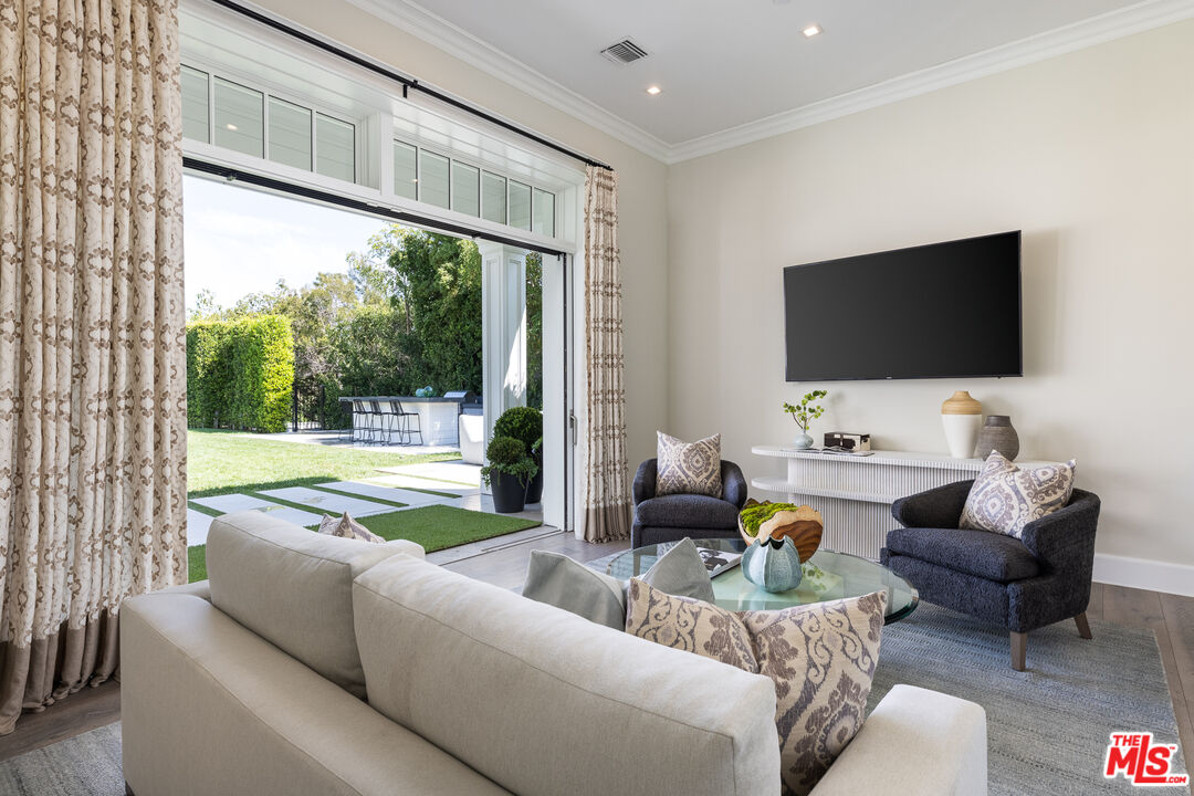 624 North Bonhill Road Los Angeles, CA 90049 - Photo 38 of 48 a living room with furniture a flat screen tv and a floor to ceiling window