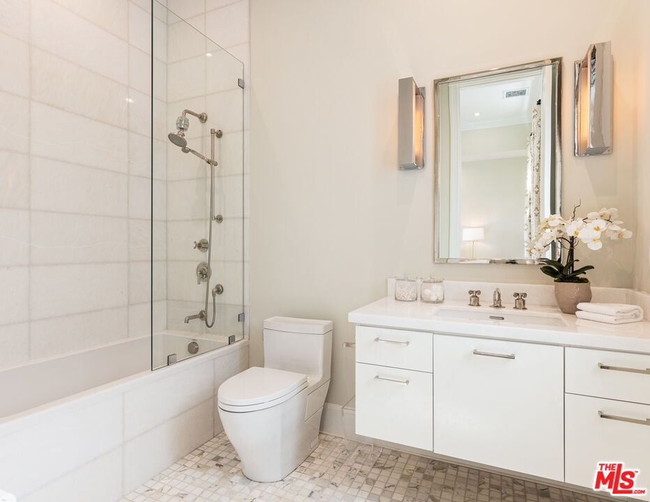 624 North Bonhill Road Los Angeles, CA 90049 - Photo 39 of 48 a bathroom with a toilet a sink a mirror a bathtub and shower