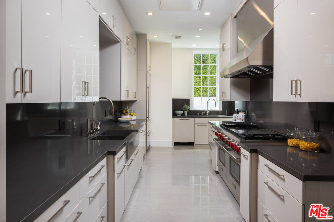 624 North Bonhill Road Los Angeles, CA 90049 - Photo 10 of 48 a kitchen with stainless steel appliances granite countertop a stove a sink and a refrigerator
