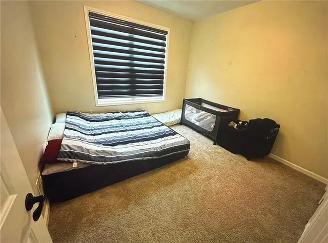 a bed sitting in a bedroom next to a window