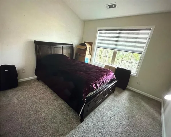 a bed sitting in a bedroom next to a window