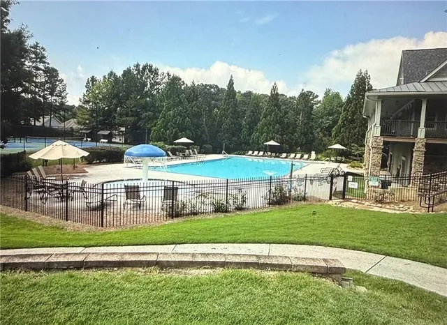a view of a house with a big yard and large trees