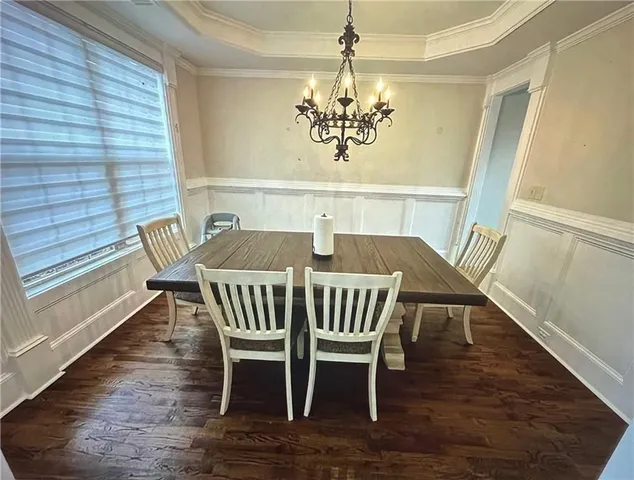 a view of a dining room with furniture a chandelier and wooden floor