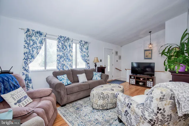 a living room with furniture a large window and a fireplace