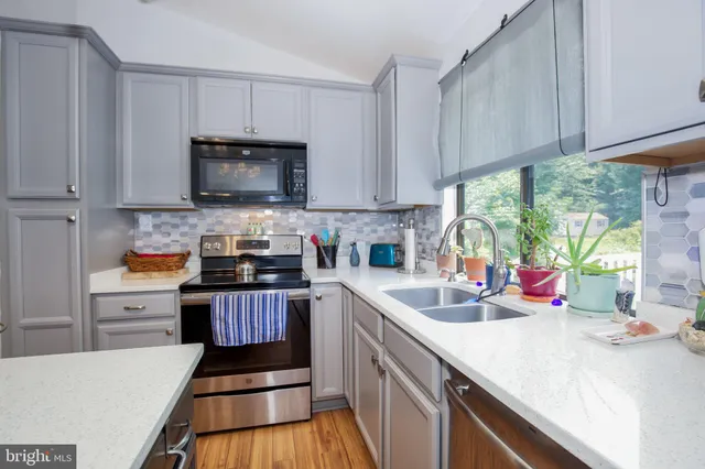 a kitchen with stainless steel appliances a stove sink microwave and cabinets