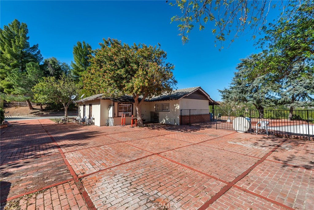 6006 Clear Valley Road Hidden Hills, CA 91302 - Photo 6 of 10 a yellow house with trees in front of it