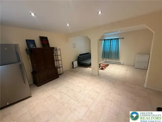 a view of an empty room with furniture and closet