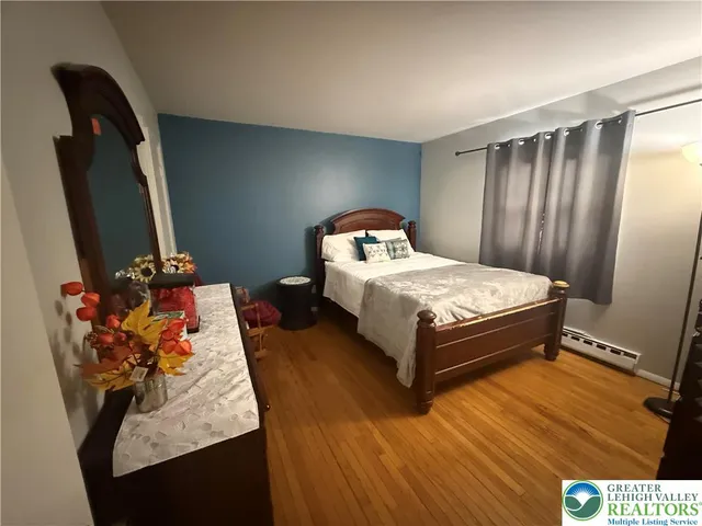a bedroom with a bed and dresser with mirror