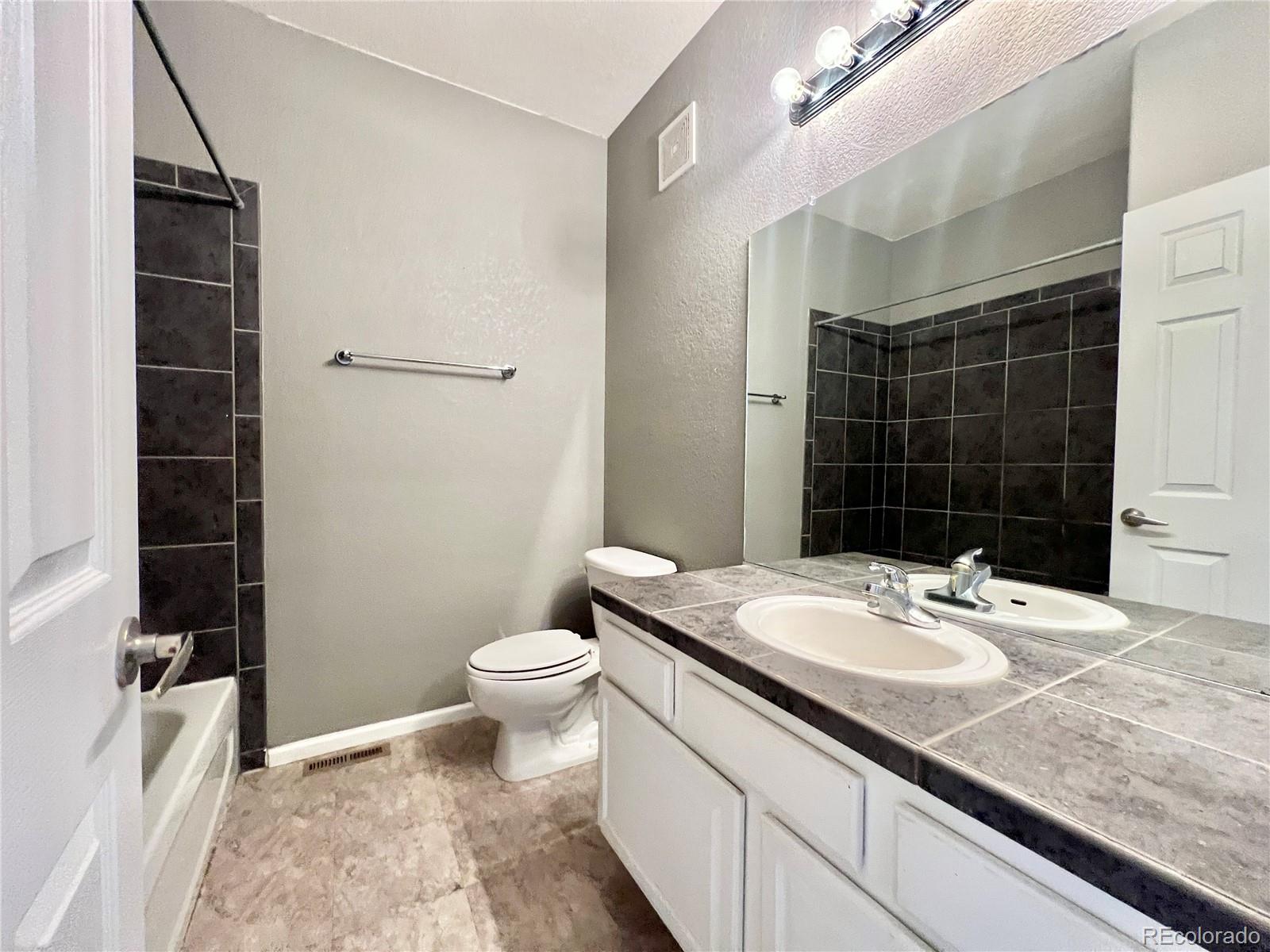 1385 South Chambers Road, Unit 102 Aurora, CO 80017 - Photo 18 of 20 a bathroom with a sink a toilet and shower