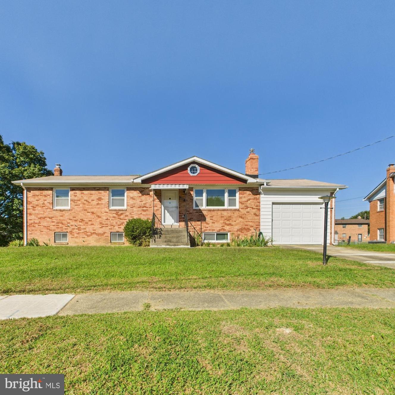 Charming brick home with lush green lawn.