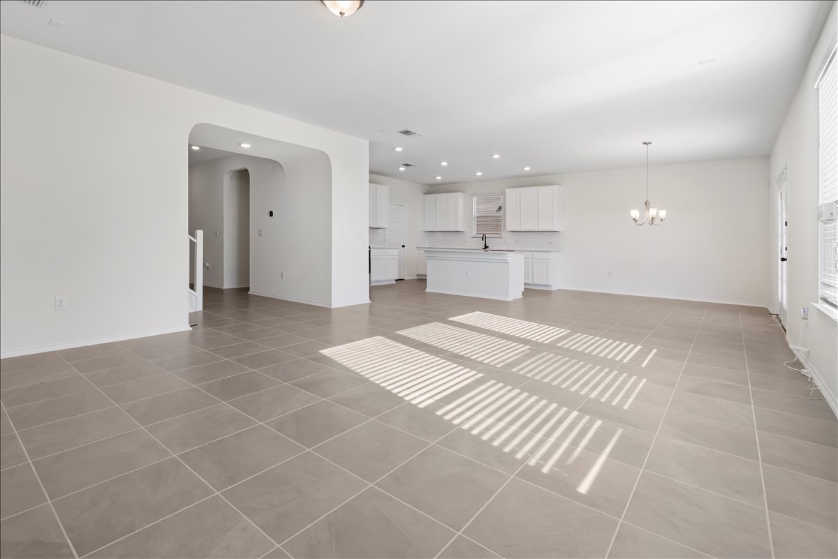 18501 Spotted Eagle Lane Elgin, TX 78621 - Photo 12 of 40 Natural light illuminates the open-concept living space, highlighting the pristine tile flooring.