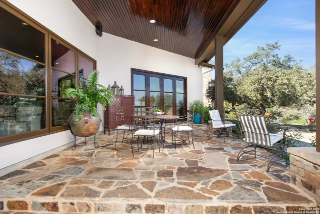 a view of a porch with chairs and potted plants