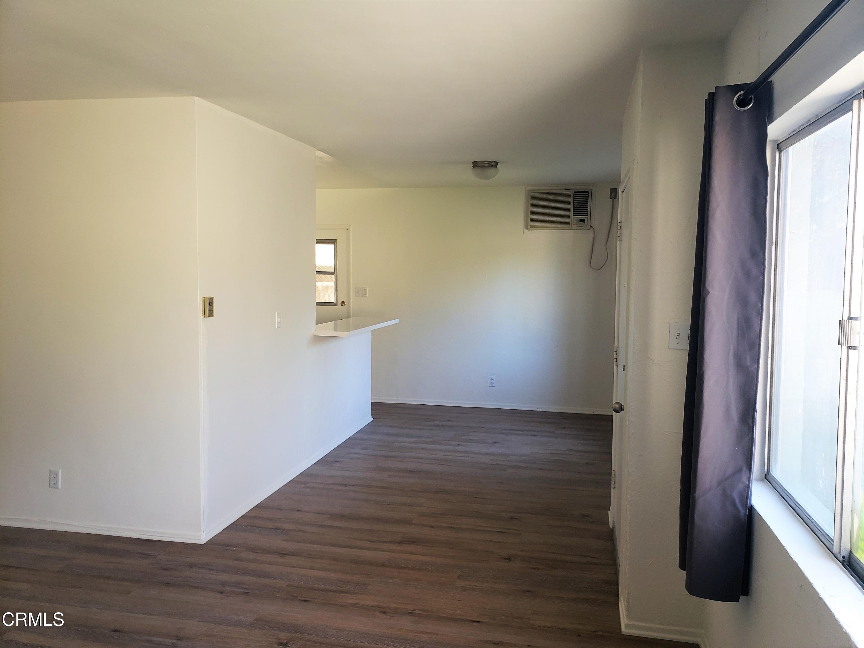 7143 Hillrose Street Tujunga, CA 91042 - Photo 4 of 13 a view of a hallway with wooden floor and a bathroom