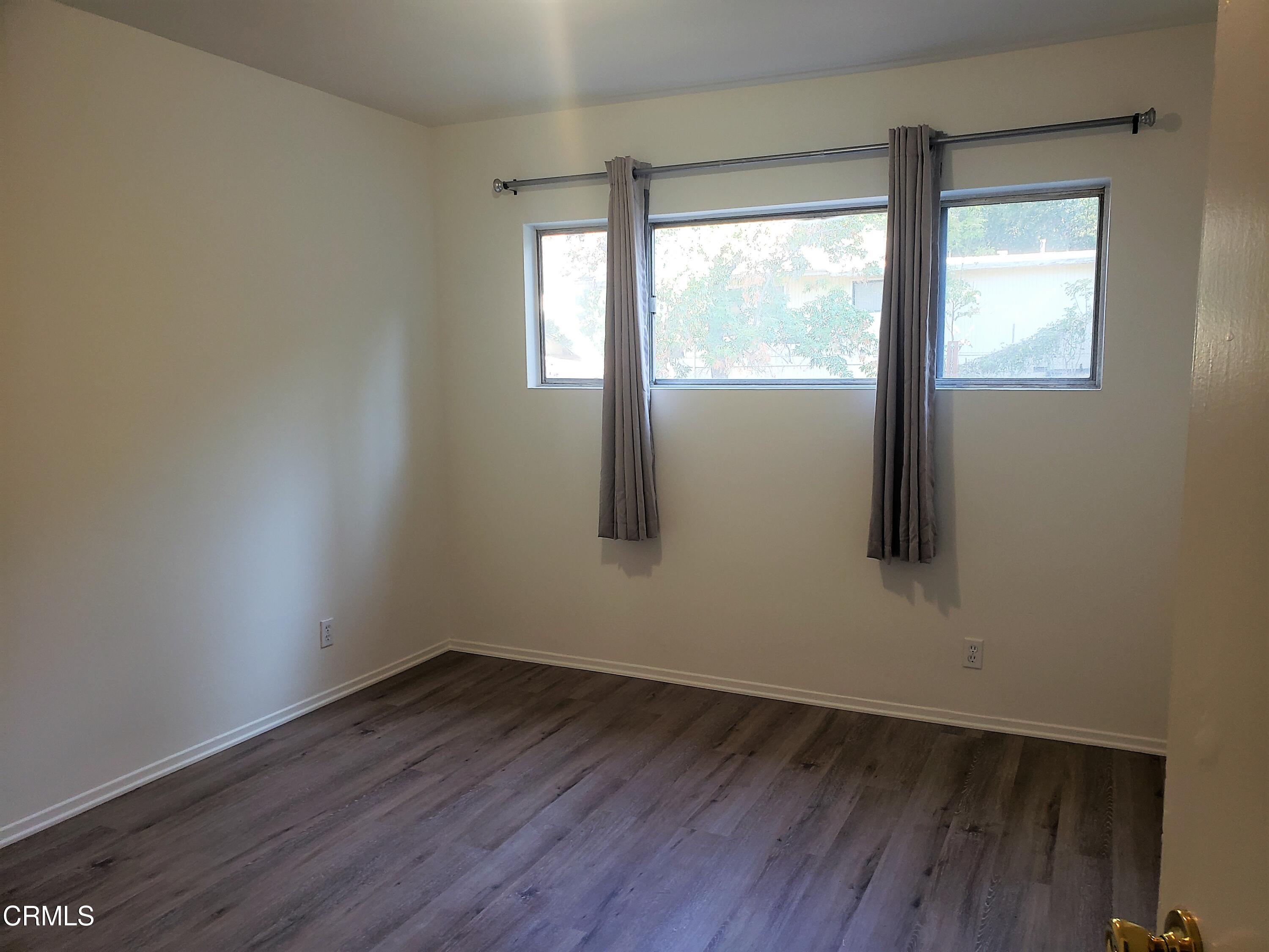 7143 Hillrose Street Tujunga, CA 91042 - Photo 9 of 13 an empty room with wooden floor and windows