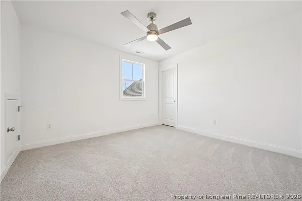 an empty room with a ceiling fan and a window