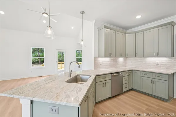 a kitchen with a sink dishwasher a stove and a refrigerator with wooden floor