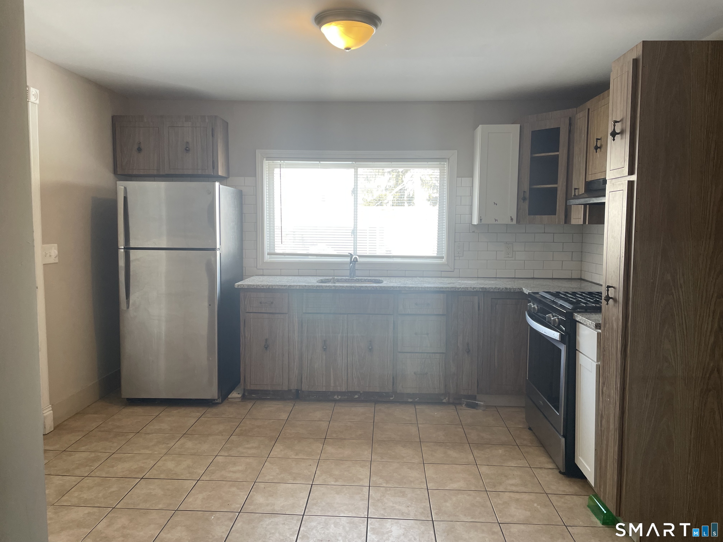 227 Arctic Street Bridgeport, CT 06608 - Photo 15 of 19 a kitchen with a refrigerator and a stove top oven