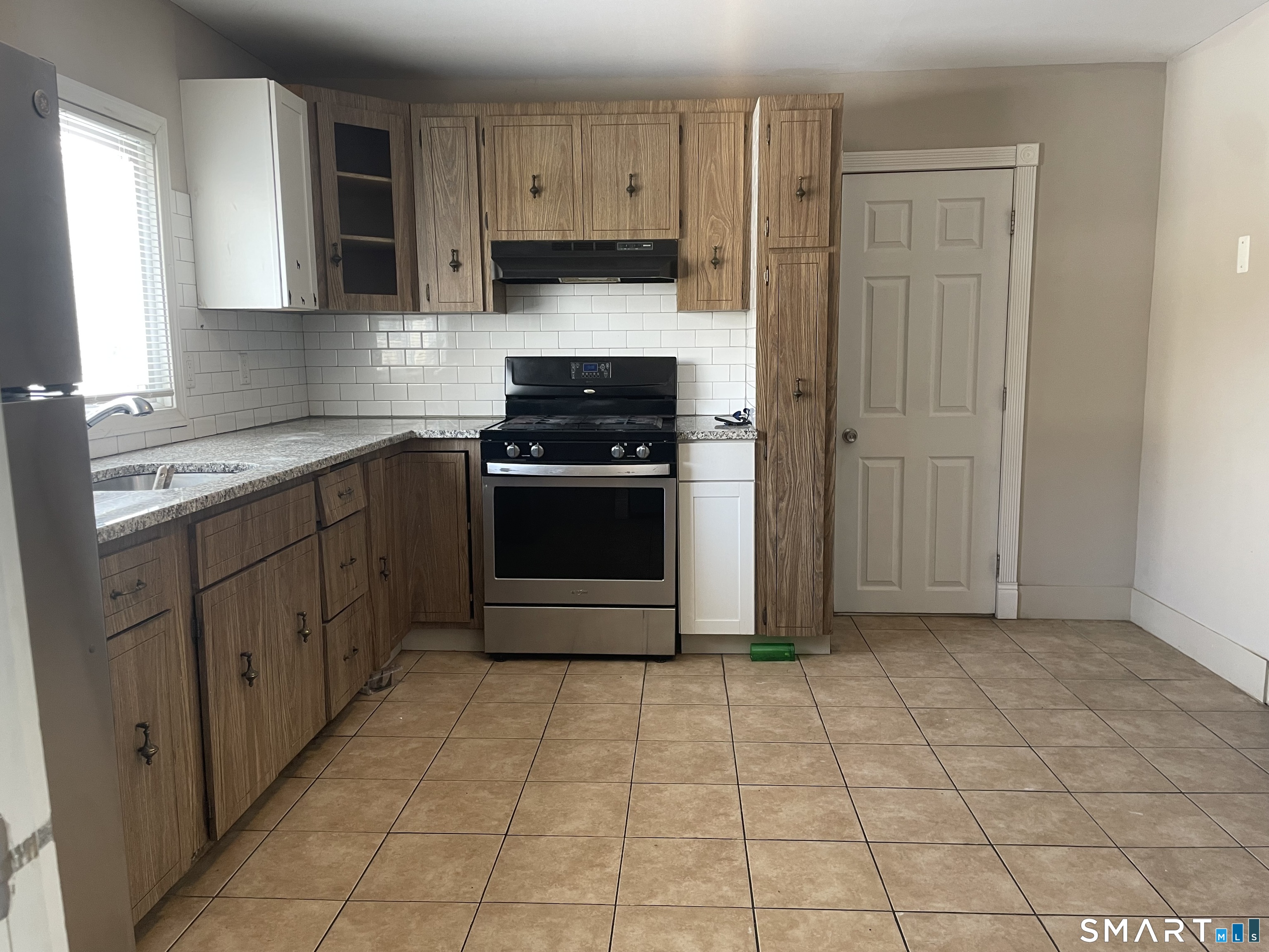 227 Arctic Street Bridgeport, CT 06608 - Photo 16 of 19 a kitchen with stainless steel appliances granite countertop a stove a sink and a refrigerator
