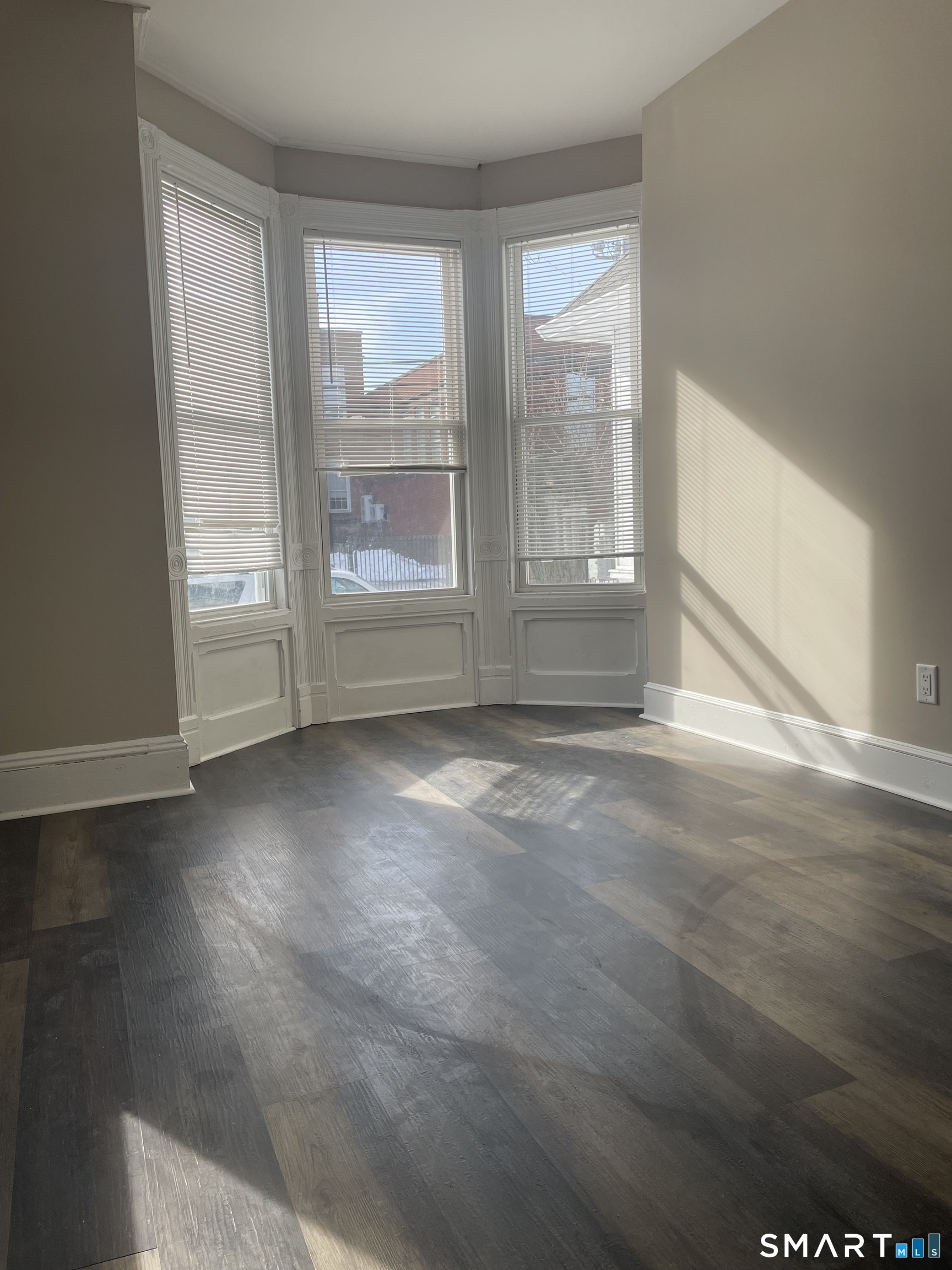 227 Arctic Street Bridgeport, CT 06608 - Photo 5 of 19 an empty room with wooden floor and windows