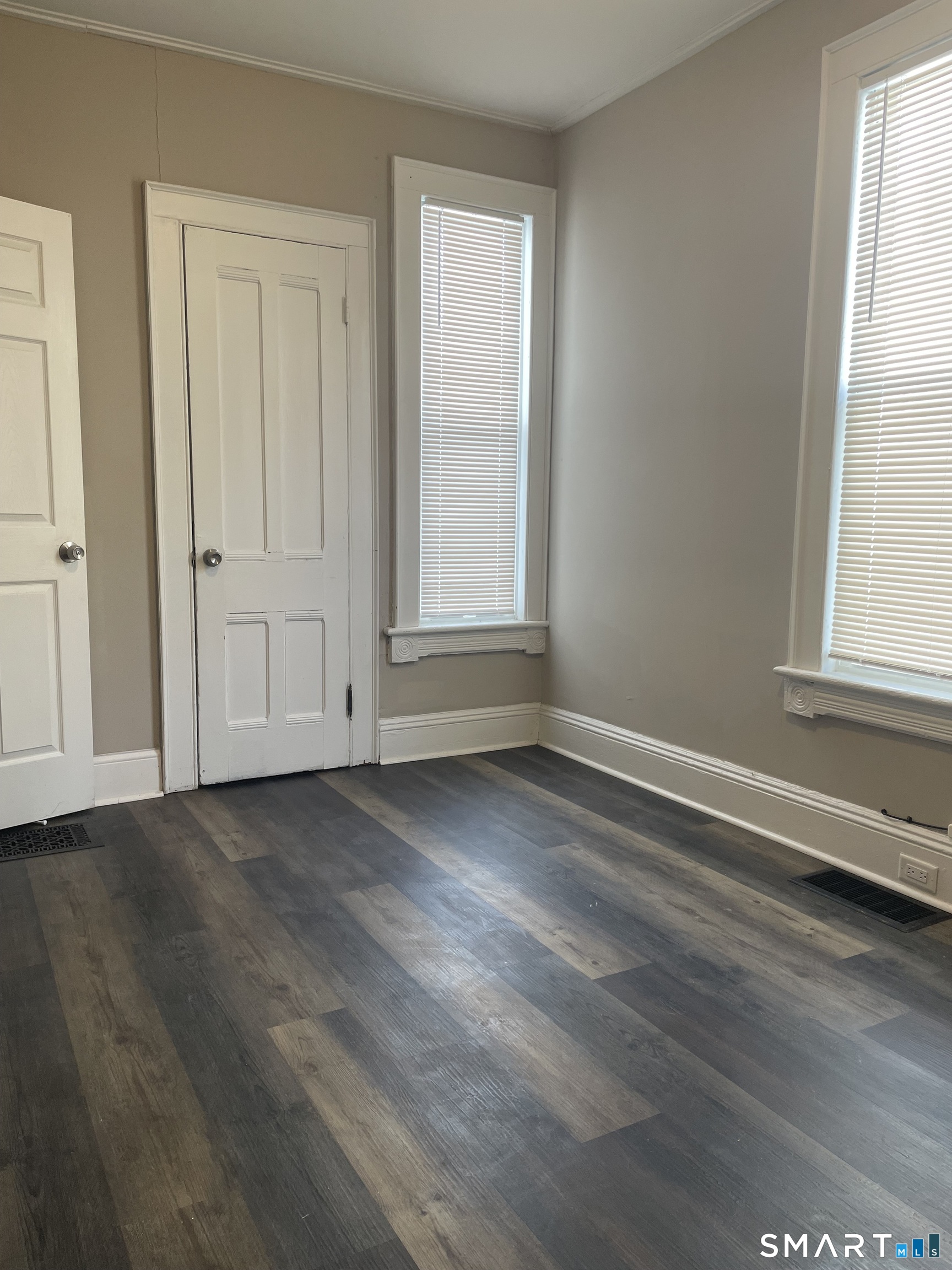 227 Arctic Street Bridgeport, CT 06608 - Photo 8 of 19 an empty room with wooden floor and windows