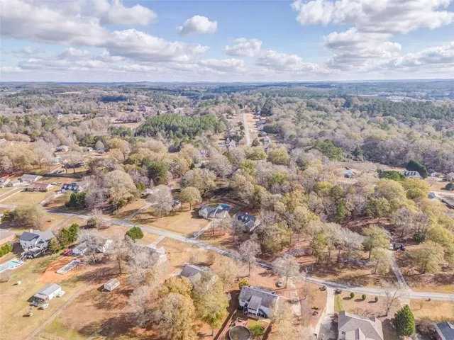 a bathroom with a granite countertop sink two mirror and a shower