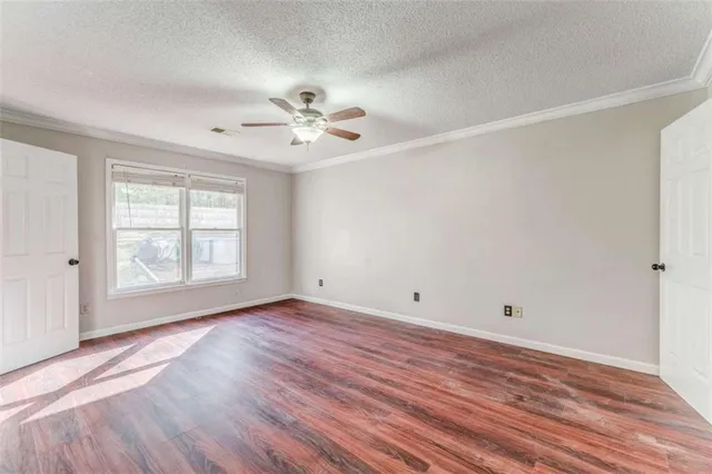 wooden floor in an empty room with a fan