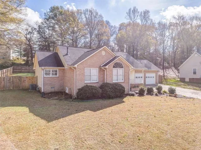 a front view of a house with a yard covered in snow