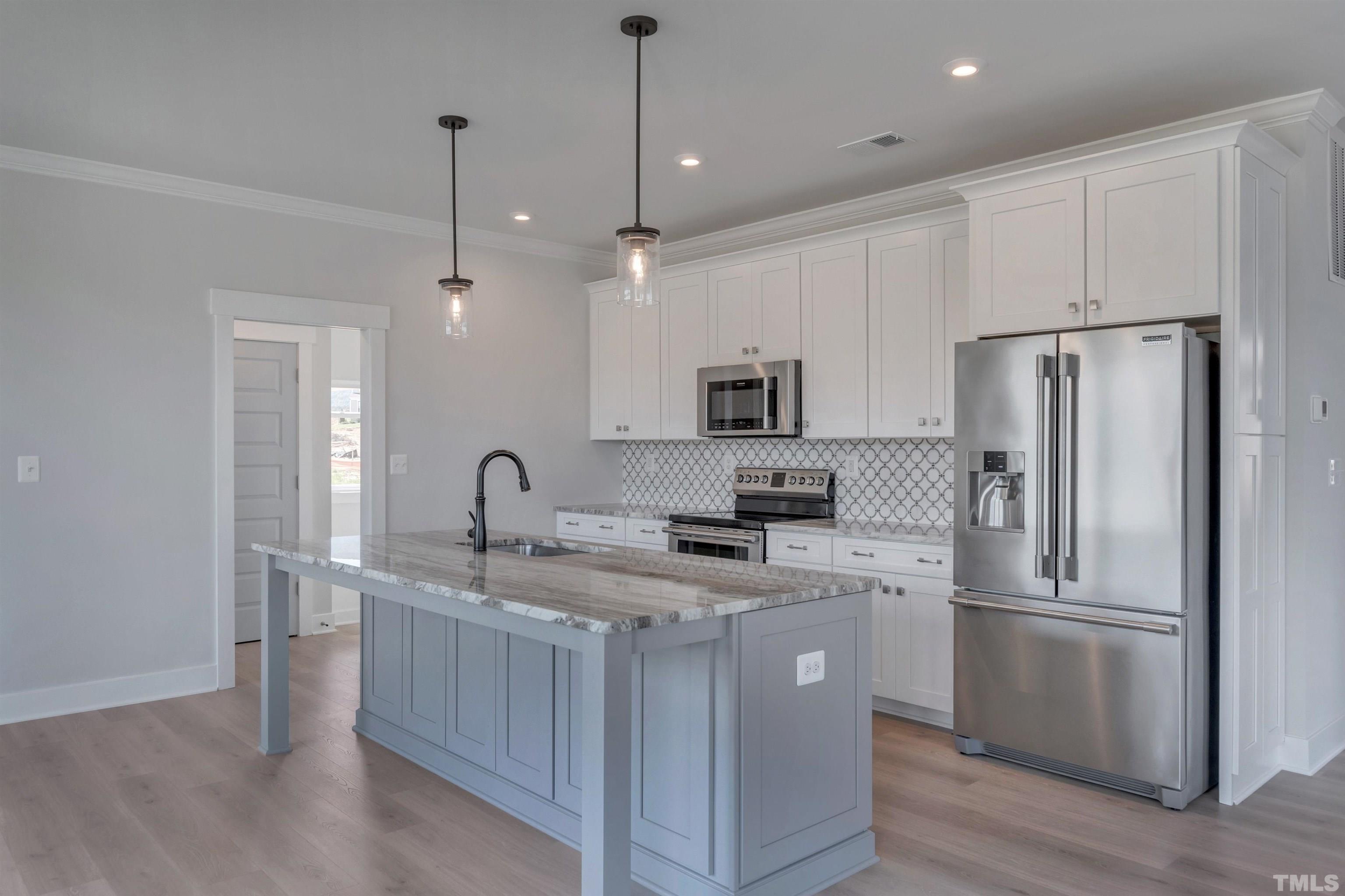 175 Dunloe Loop Raleigh, NC 27603 - Photo 3 of 14 a kitchen with kitchen island granite countertop appliances cabinets a sink and a center island