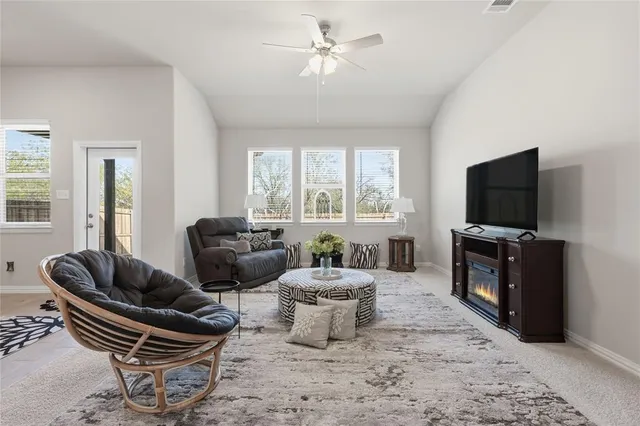 a living room with furniture a flat screen tv and a large window