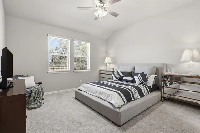 a spacious bedroom with a bed and a flat screen tv